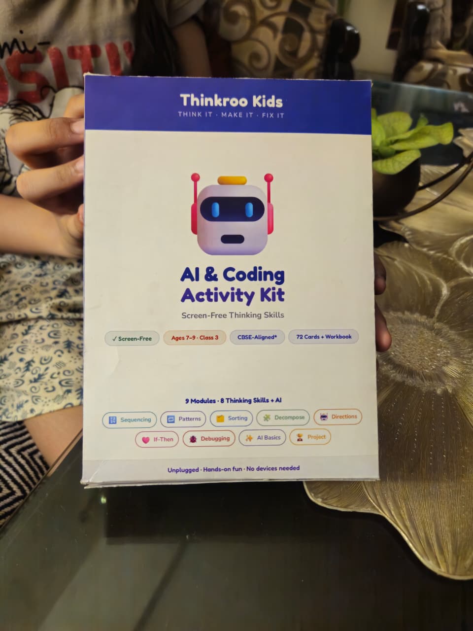 Hands opening a Thinkroo Kids kit box